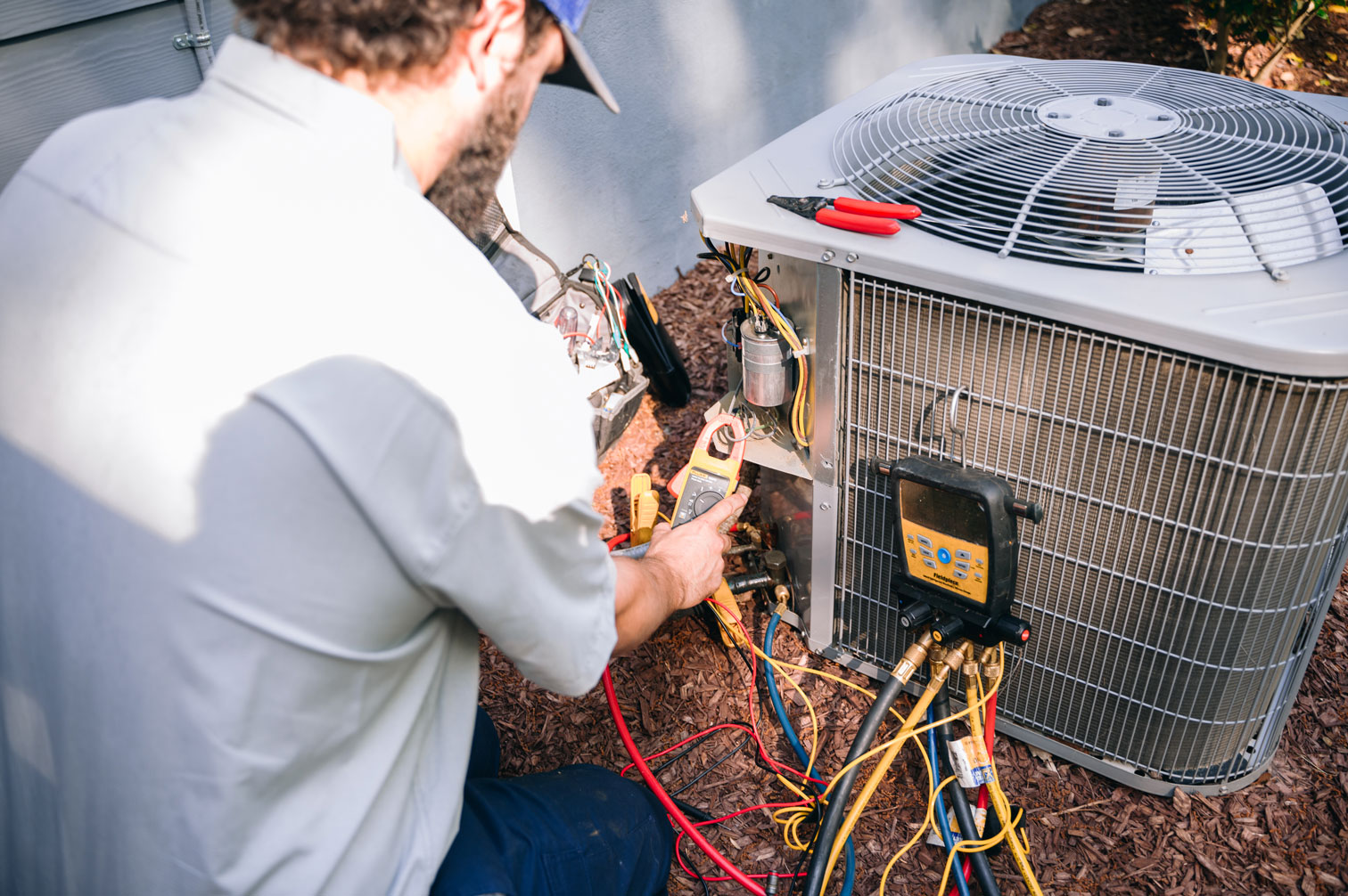 HVAC technician repairing an air conditioning unit in Raleigh, NC