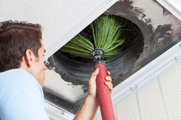 Technician cleaning an air duct